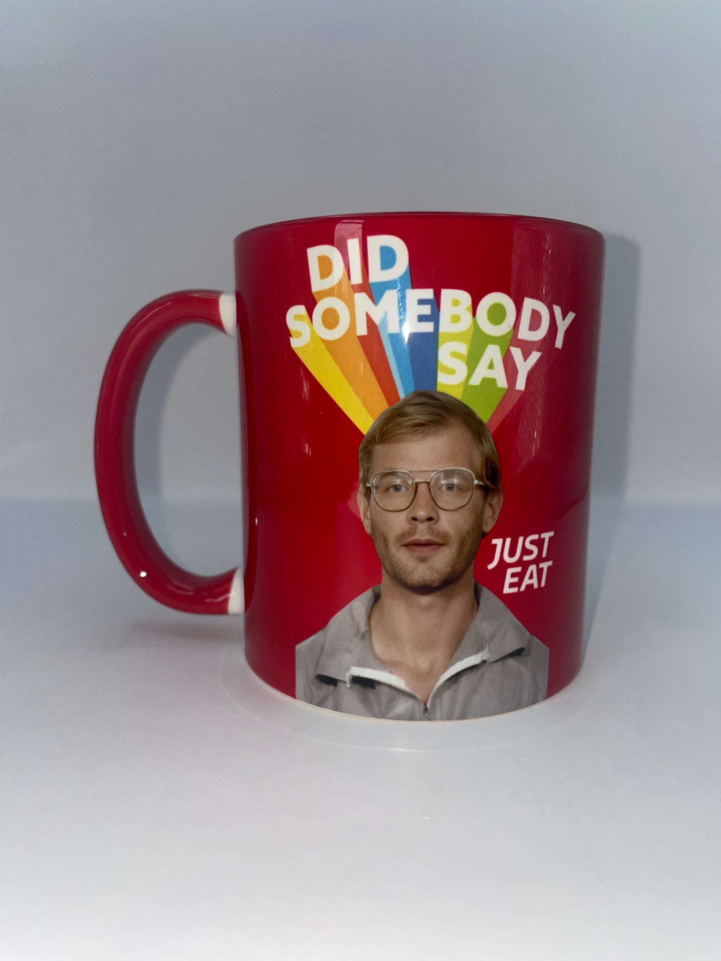 Red mug with a printed face and text on a white background