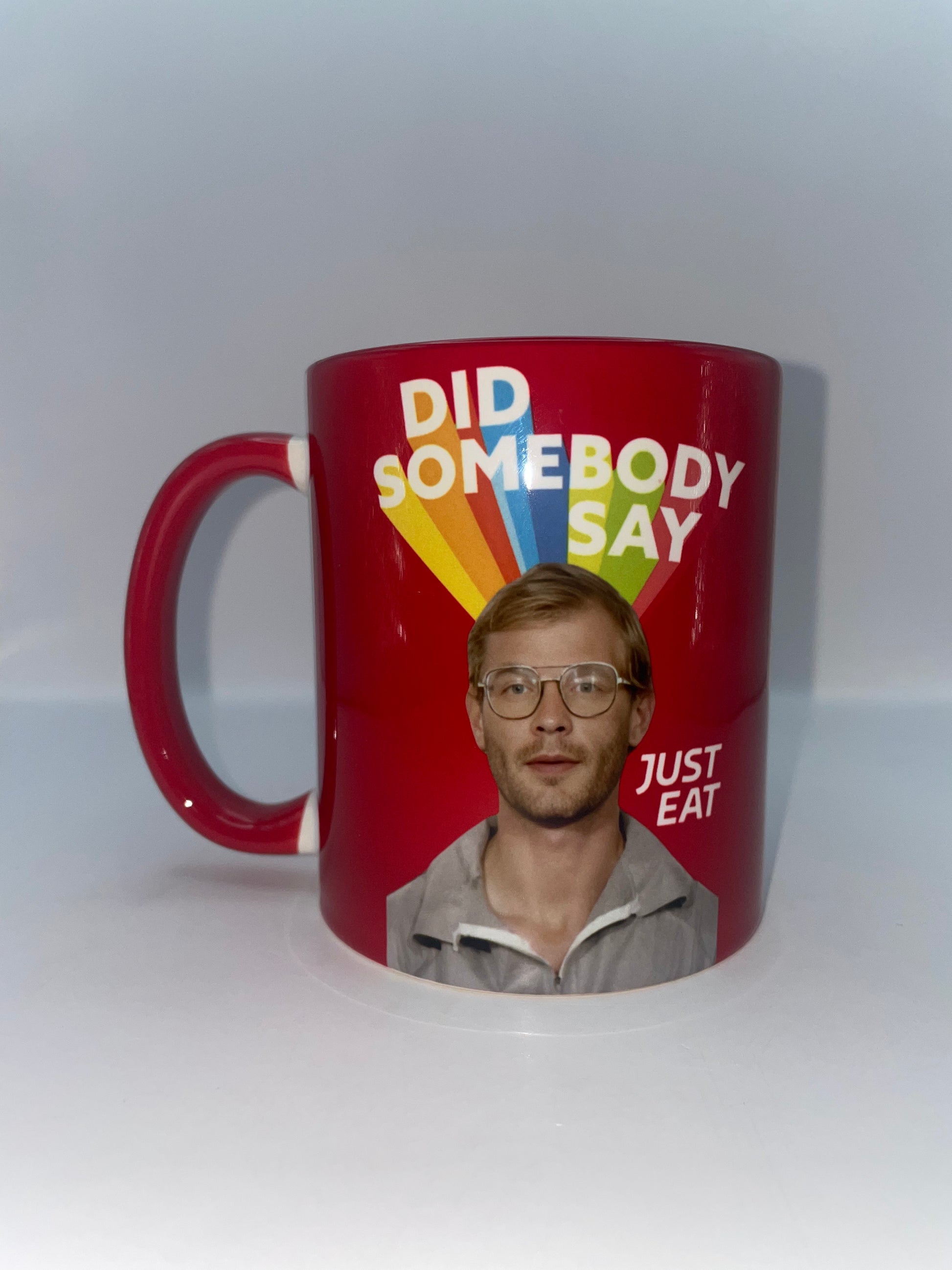 Red mug with a graphic of a man's face and text on a white background