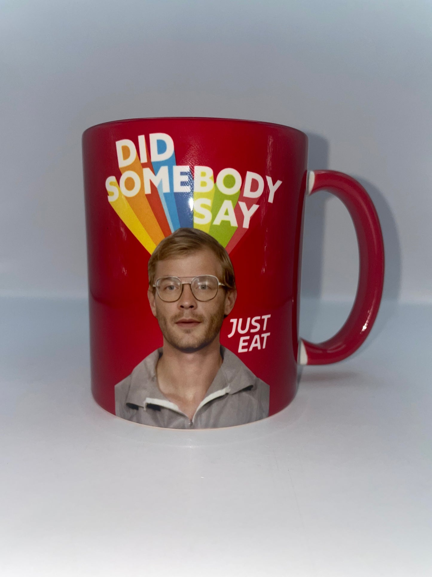Red mug with a printed design of a man's face and text on a white background